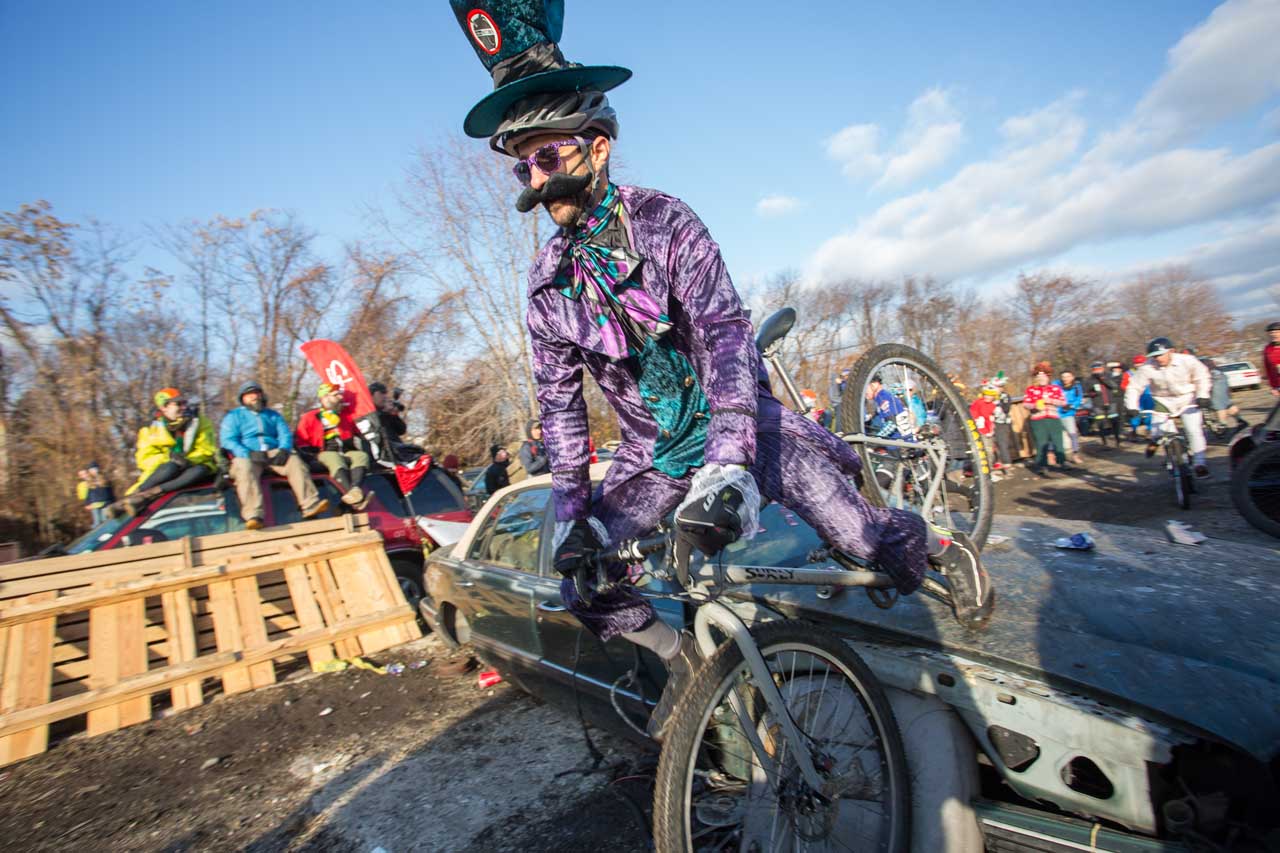 A costumed rider falls over a carhood at the Bilenky Junkyard Cross Race for the SSCXWC in Philadelphia, PA.
