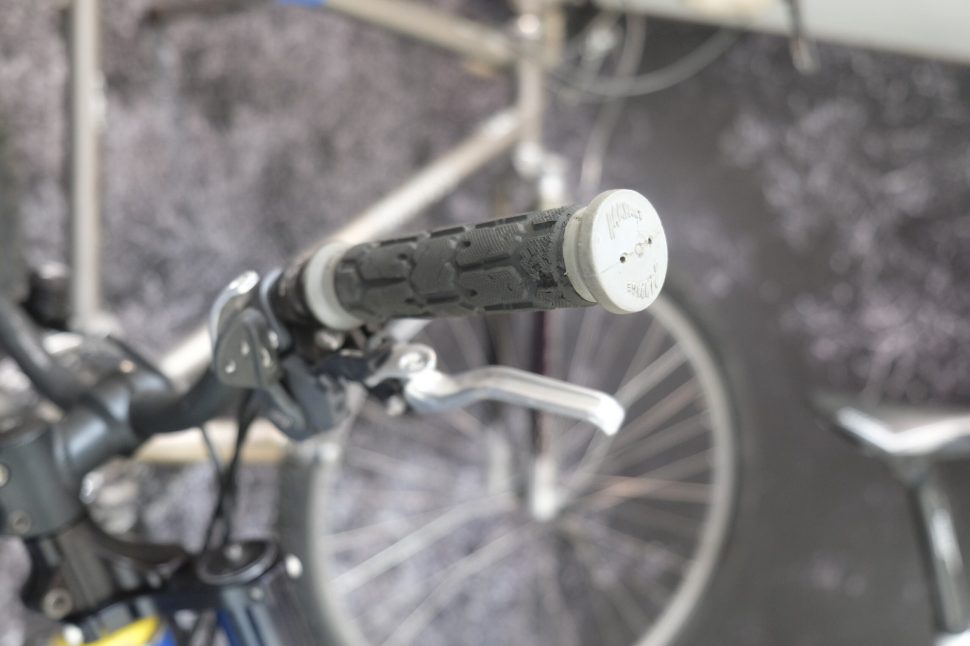 Close-up view of a bicycle handlebar with a push-on grip and brake lever, showcasing the grip texture and design.