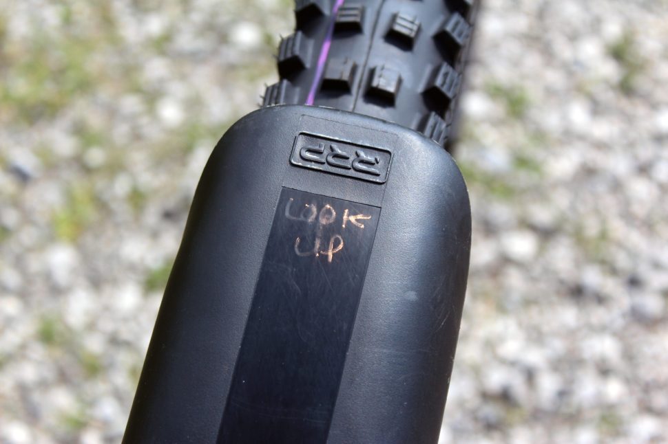 Close-up of a bicycle tire with a visible marking that reads 'LOOK UP' on its tread.