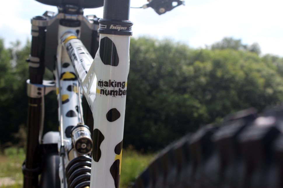 Close-up view of a bike frame featuring a unique black and white spot design with the text 'making up numbers' visible.