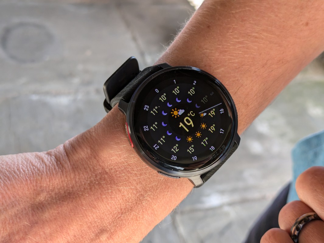 A smartwatch displaying weather information and temperature on a person's wrist.