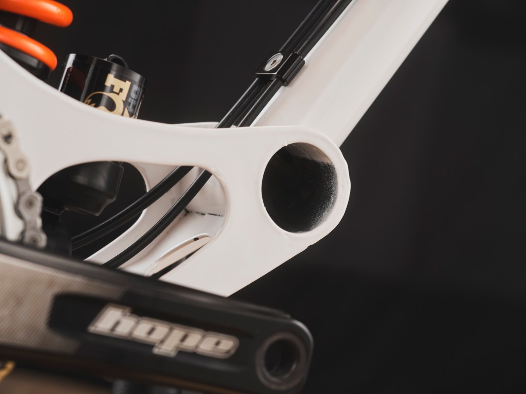 Close-up of a custom bike frame highlighting the bottom bracket area and shock mount, showcasing the detailed design and unique gusset structure.