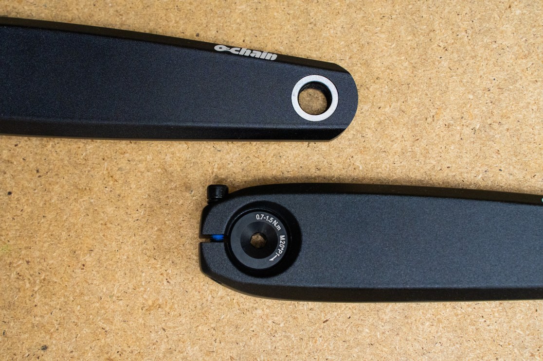 Close-up of a black Ochain ebike crankset mounted on a wooden surface, showing detailed design and structure.