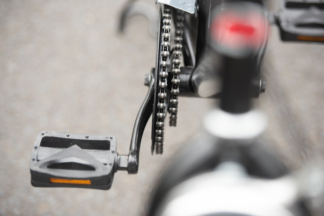 Close-up of a bicycle pedal and chain, showcasing the bike's drivetrain components.