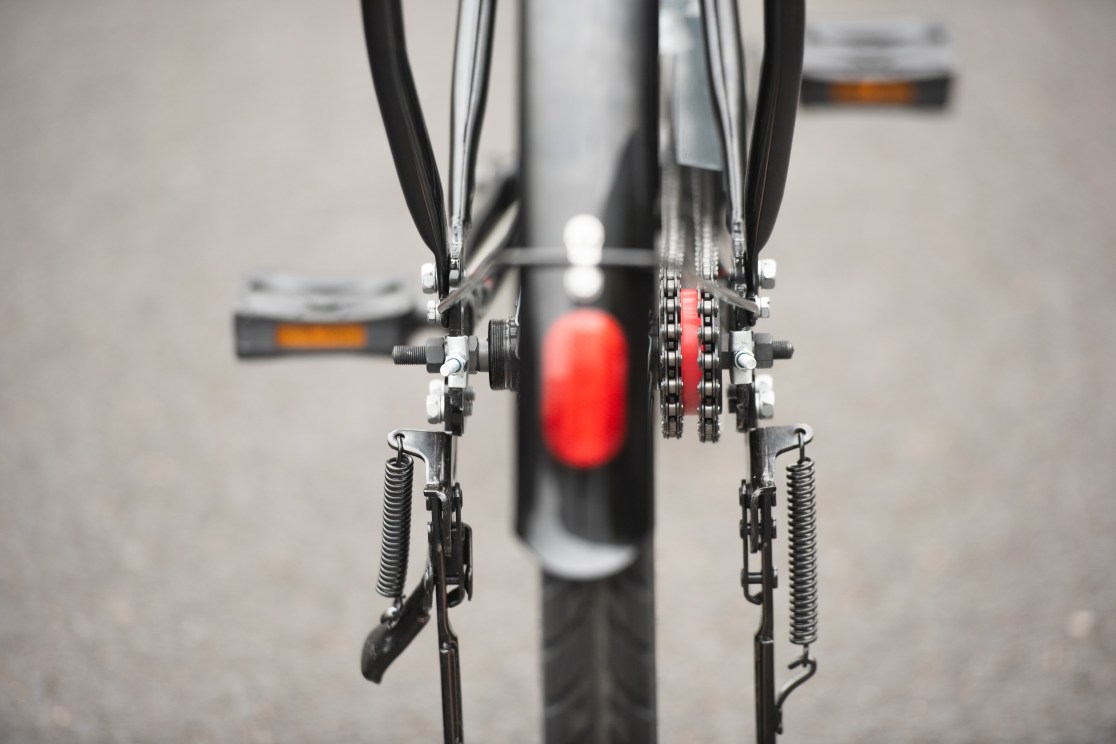 Close-up view of the rear components of a bicycle, including the chain, gears, and pedals.
