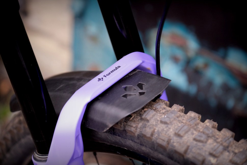 Close-up view of a mountain bike front fork mounted on a tire, showcasing the fork's design and features.
