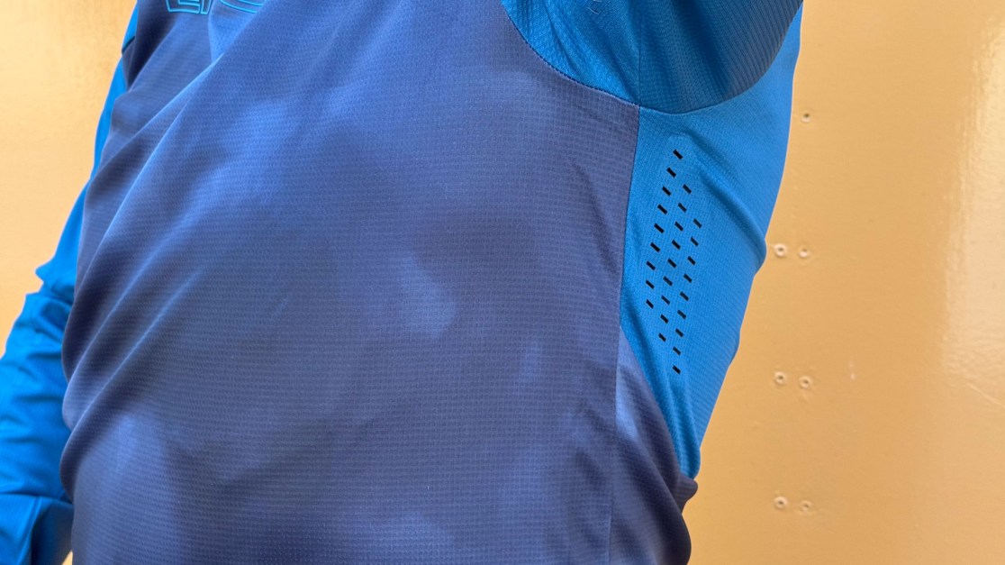 Close-up of a blue jersey featuring mesh panels for breathability.