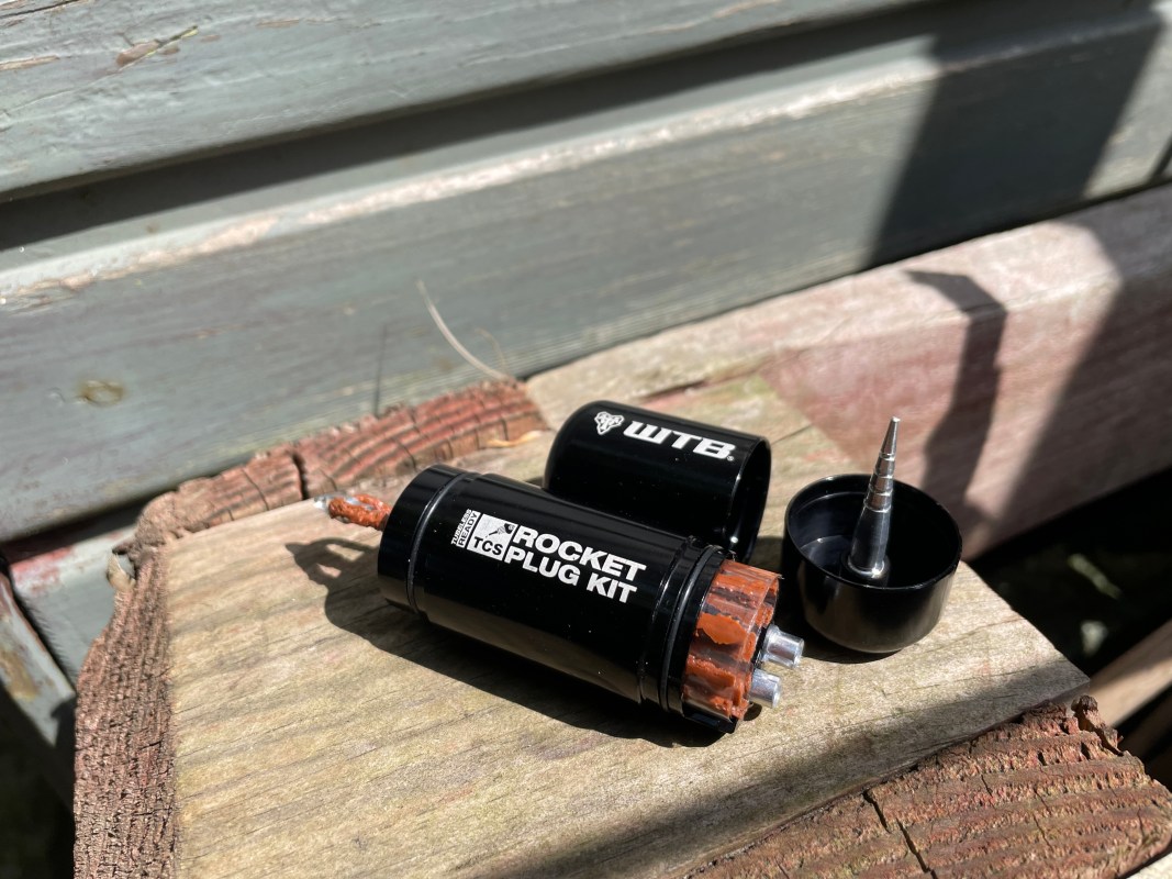 Close-up of a WTB Rocket Plug Kit displayed on a wooden surface, showcasing the tool's body and plug components.