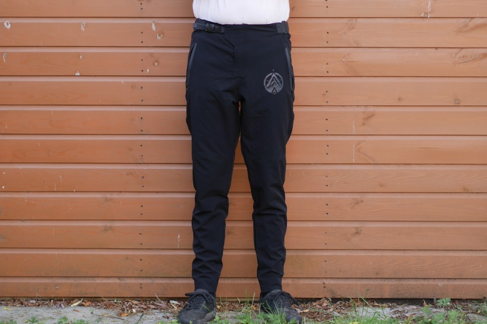 Person wearing Blackline Exile MTB trousers in front of a wooden wall.