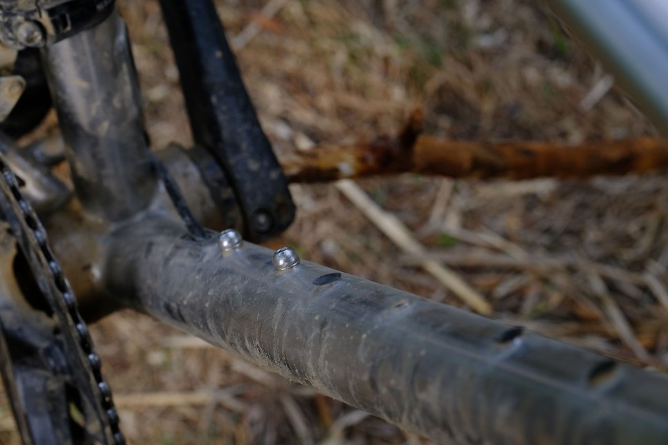 Close-up view of the bottom bracket area of a gravel bike, showcasing the frame's design with noticeable accessory bosses.