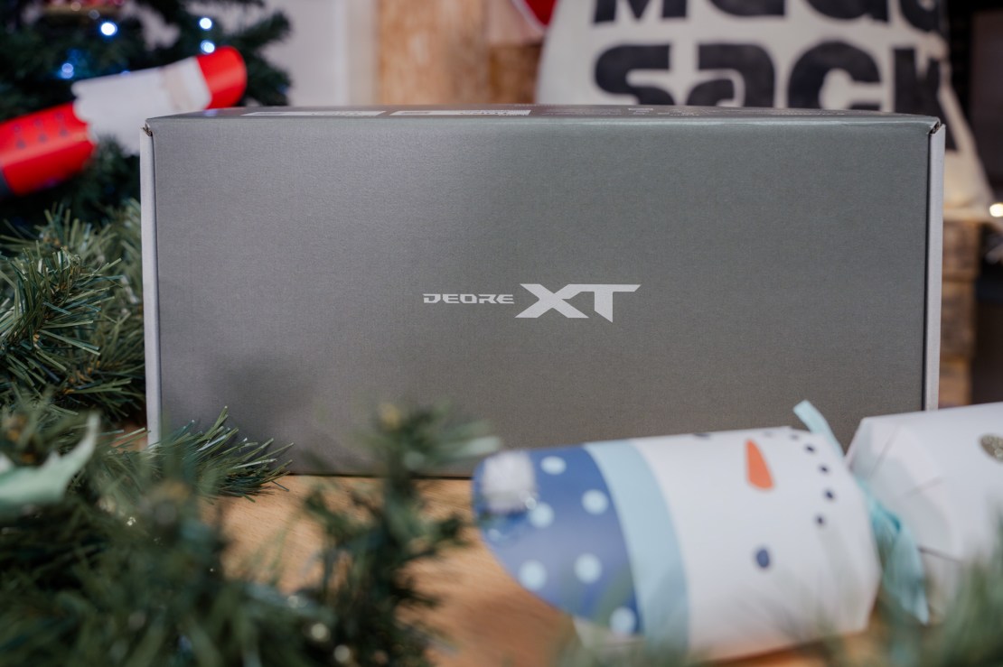 A close-up of a Shimano Deore XT box surrounded by festive decorations and wrapped presents.